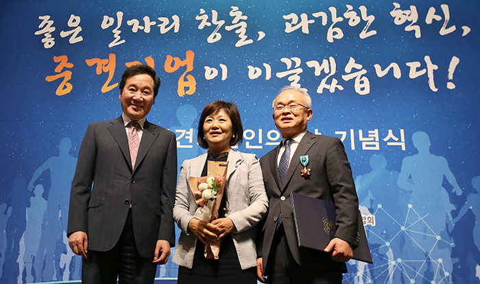 Prime Minister Lee Nak-yon (left) poses for a photo with CEO Ahn Yoon-Soo of Shinsung ENG, a solar energy company, after presenting him an award.